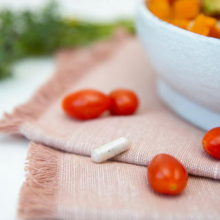 Probulin probiotic supplement capsule alongside serving of fresh vegetables on tabletop.
